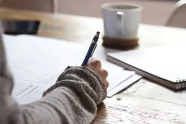 Person with pen writing notes