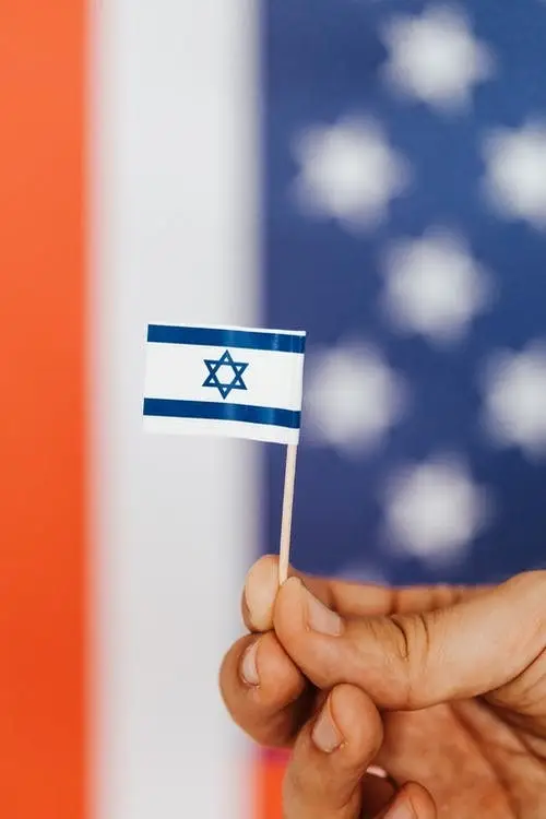 A person holding a miniature version of the Israel flag