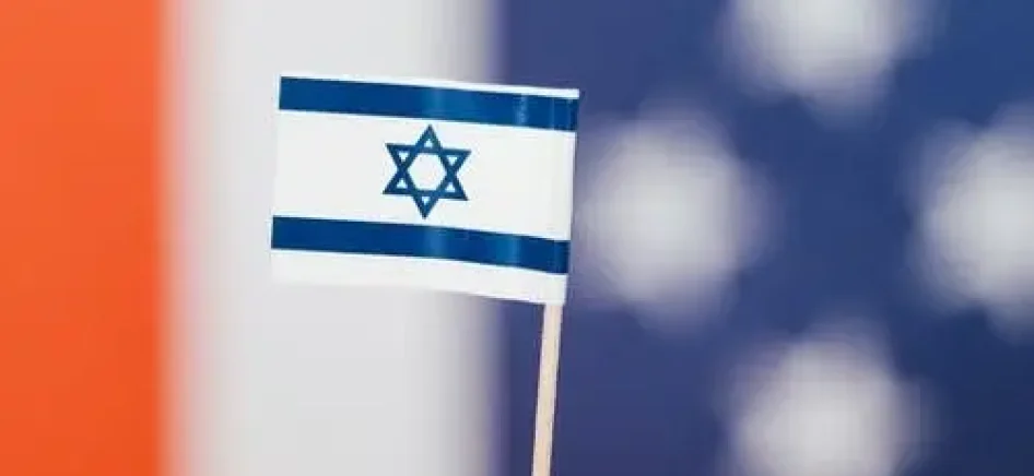 A person holding a miniature version of the Israel flag