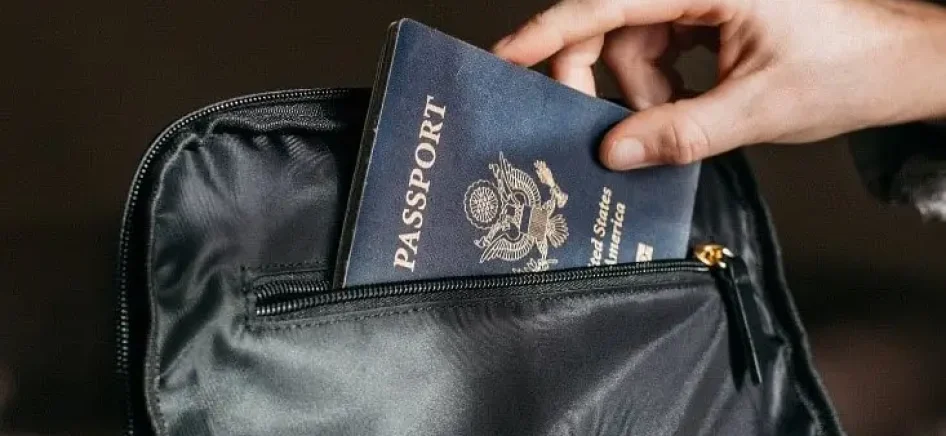 A person putting their passport in a bag-min