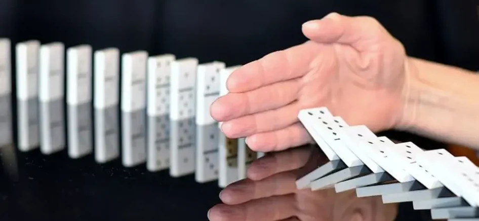 Hand stopping the domino effect halfway