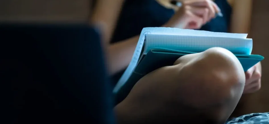 Woman sitting and writing down on pape
