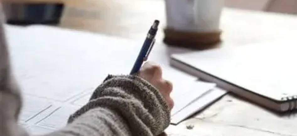 Person with pen writing notes